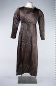 Man's brown silk dressing robe. Quilted and hand-stitched at hem, cuffs, and collar. Closes with a ribbon and a multi-colored cord that are both attached to the back of the garment. Robe has gauging along waistline, glazed cotton lining, long sleeves, and slits on both sides of waist for access to pockets underneath.