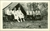 A group sitting outside an open tent at Camp Hutzler. Established by Albert and Joel Hutzler, of the Baltimore-based Hutzler's department store, the camp ran from 1921 to 1923. From July through September, employees of Hutzler's could go to the camp, located in the Patapsco Forest Preserve in Ellicott City, Maryland, and enjoy leisure time…