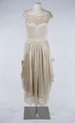 Ivory silk dress with low, wide lace neckline, gathered waist, lace trim, and butterfly detail.