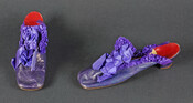 Pair of purple leather ladies' slippers with rounded square toe and low heel. Bound with box-pleated purple silk ribbon and further embellished with larger purple silk ribbon on vamp. Soles are leather.