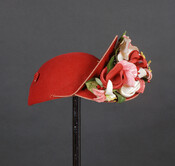 Ladies' red wool felt hat embellished with red, white, and pink faux flowers on one side.