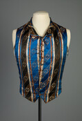 Blue and brown silk brocade waistcoat. Throughout fashion history, both men and women undertook stratagems to attain an era’s fashionable silhouette. In the 1830s, when a broad chest and a narrow waist constituted the ideal masculine physique, tailors sculpted men’s figures by padding out a waistcoat’s lining in the chest, as was done in Dr.…