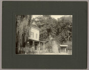 View of the southern entrance of the Tolchester Beach Amusement Park in Tolchester, Maryland. On the left stands a house, with a small shed to the right. This Kent County park consisted of a bathing beach, amusement park, racetrack, and hotel, and was in operation from 1877 to 1962. It was a popular vacation destination…