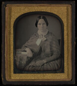 Daguerreotype portrait of an unidentified young woman resting her arm on a table.