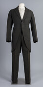 Men's twill weave morning suit. Lined with silk twill and closes with resin buttons. Although no information survives regarding the original wearer of this dark green plaid suit, stamped on the jacket’s inside pocket is “Paul Edel, Costumer, Baltimore, Md.” Edel owned a shop on 204 West Monument Street, directly across from the Maryland Historical…
