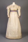 During the 1820s, the columnar gowns of the first two decades of the nineteenth century began to move towards the fuller skirts and wider sleeves associated with the Romantic era. While its fabric is very light with delicate woven feathers on a thin silk gauze, the trim of the dress has a much more masculine…