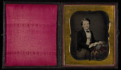 Daguerreotype portrait of William Morris as a child posing with an open book.