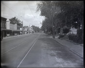 Looking north along the 4600 block of Falls Road from West Cold Spring Lane in the Cross Keys Village neighborhood of Baltimore, Maryland. Rowhomes, an automobile, and streetcar tracks are visible. Named after a nearby inn, Cross Keys Village was established by African Americans after the Civil War. In the 1960s, the majority of the…