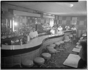 Group portrait of staff members standing behind a waved bar/counter in a restaurant or club. Possibly Sphinx Club or Club Casino, Baltimore, Maryland.