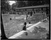 People jumping into the water at Pool Number 2 located in Druid Hill Park. Pool Number 2 served the recreational needs of Black residents during the time of segregation in Baltimore, Maryland. The pool served over 100,000 Black residents, despite measuring 100 x 105 feet, half the size of whites-only Pool Number 1.