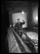 A man holding up a cup of beer at the National Brewing Company, once located at Dillon, O'Donnell, and Conkling Streets in the Highlandtown neighborhood of Baltimore, Maryland.