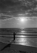 A person fishing from the beach.